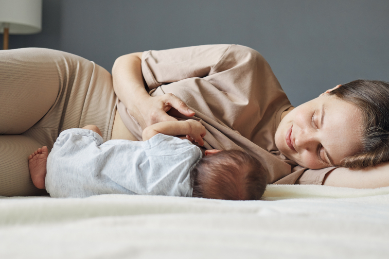 Caucasian beautiful mother breastfeeding her baby while lying on bed - Lactation Consultant in Madison WI Caucasian beautiful mother breastfeeding her baby while lying on bed - Lactation Consultant in Madison WI