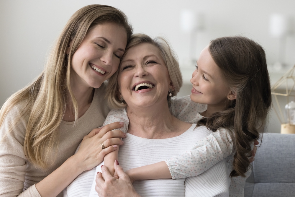 Three Generations Bonding with Laughter and Love - Pre-Operative Care A joyful grandmother is hugged by her daughter and granddaughter, sharing a heartfelt moment together - Pre-Operative Care